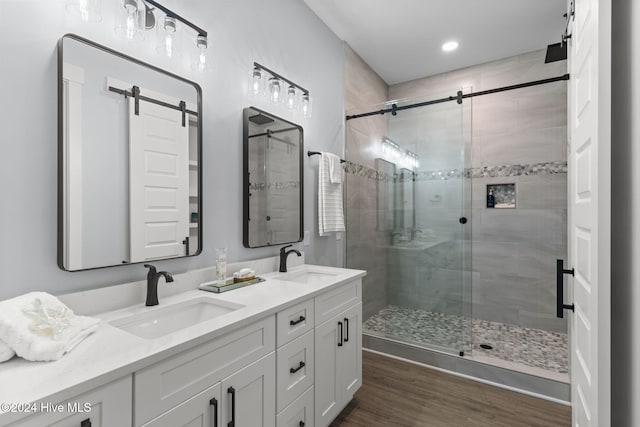 bathroom with vanity, an enclosed shower, and wood-type flooring