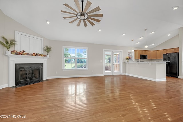 unfurnished living room with high vaulted ceiling and light wood-type flooring