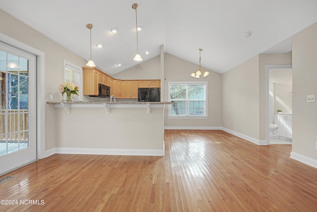 kitchen featuring light hardwood / wood-style flooring, black appliances, vaulted ceiling, pendant lighting, and light brown cabinetry