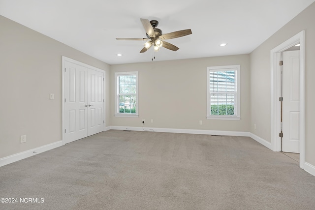 carpeted spare room featuring ceiling fan