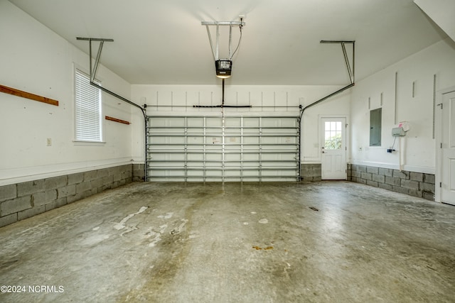 garage with a garage door opener and electric panel