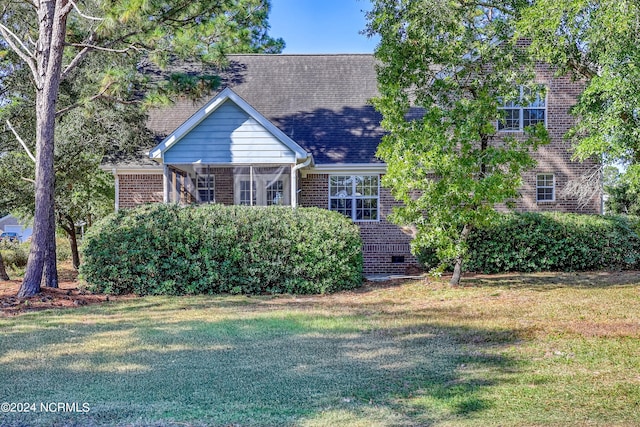 view of front of home featuring a front yard and a sunroom