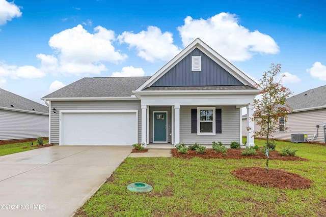 view of front of property featuring covered porch, a front yard, and a garage