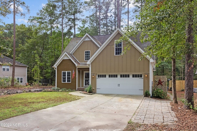 view of front facade with an attached garage, fence, driveway, roof with shingles, and a front yard