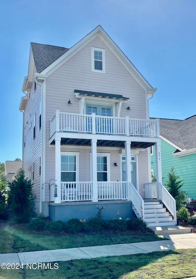 view of front of home with a balcony, a front lawn, and a porch