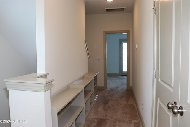 hallway with dark colored carpet