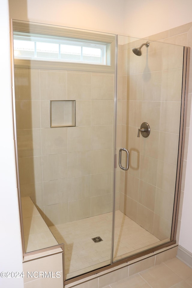 bathroom featuring a shower with door and tile patterned floors