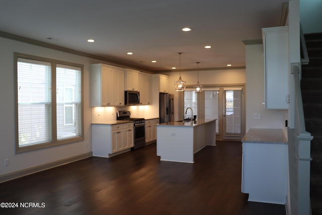 kitchen with appliances with stainless steel finishes, white cabinets, pendant lighting, a kitchen island with sink, and dark hardwood / wood-style floors