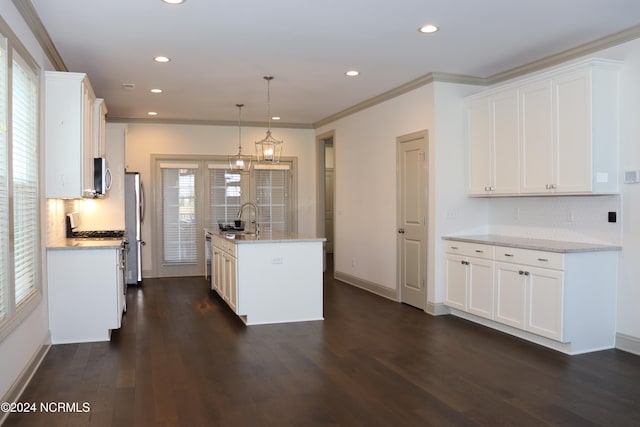 kitchen with an island with sink, white cabinets, decorative light fixtures, and dark hardwood / wood-style flooring