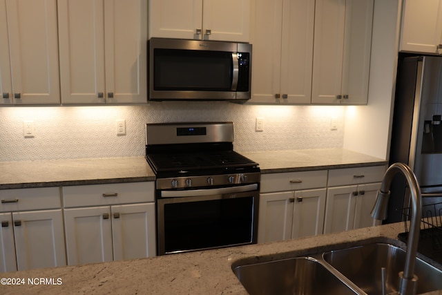 236 Trisail Ter, Wilmington, NC 28412 - kitchen with a sink, light stone counters, backsplash, and stainless steel appliances