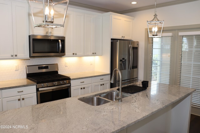 kitchen featuring white cabinetry, appliances with stainless steel finishes, hanging light fixtures, and light stone counters