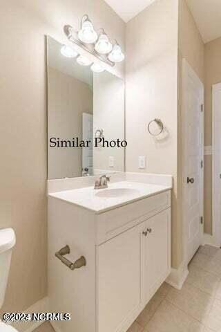 bathroom featuring vanity, toilet, and tile patterned flooring