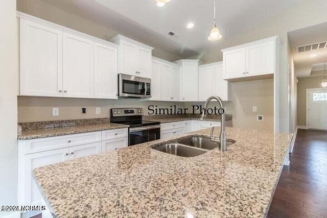 kitchen with stainless steel appliances, a center island with sink, and dark hardwood / wood-style flooring