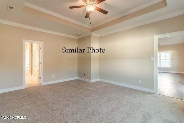 unfurnished room featuring crown molding, carpet floors, a raised ceiling, and ceiling fan