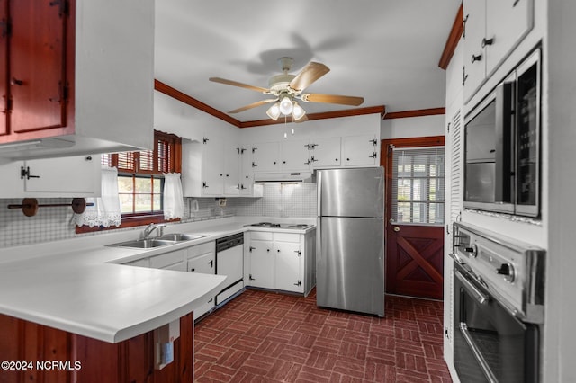 kitchen featuring kitchen peninsula, sink, white cabinetry, appliances with stainless steel finishes, and tasteful backsplash