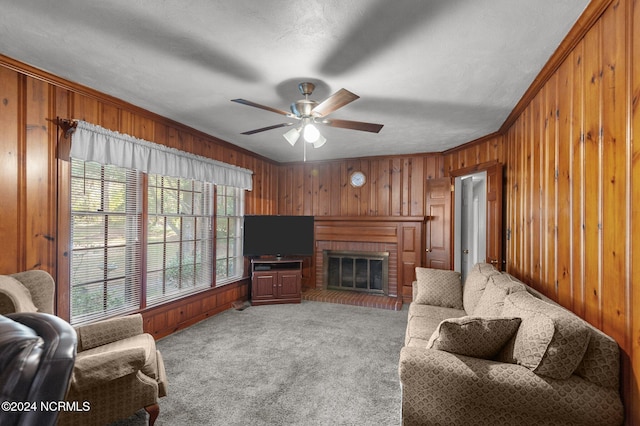 living room with crown molding, a fireplace, carpet flooring, and wood walls