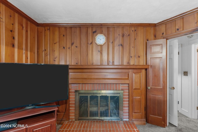 carpeted living room featuring crown molding, wooden walls, and a fireplace