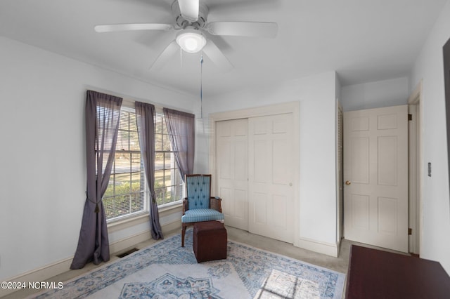 sitting room featuring ceiling fan and light colored carpet