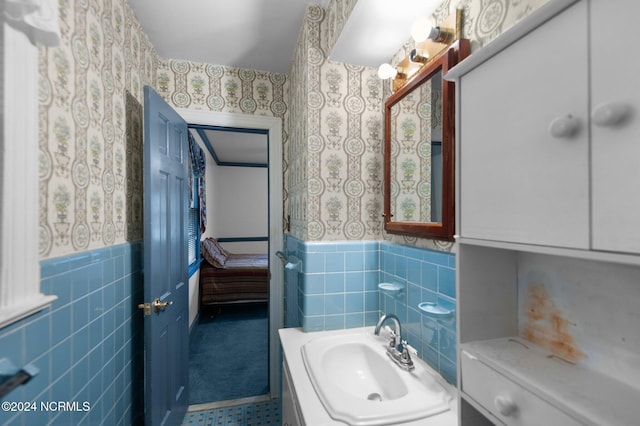 1008 S Howard Cir, Tarboro, NC 27886 - bathroom with wallpapered walls, a wainscoted wall, tile walls, and vanity
