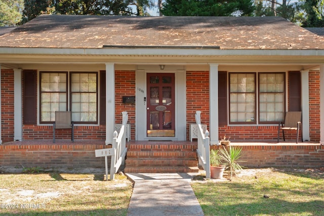 1008 S Howard Cir, Tarboro, NC 27886 - view of front of property with a porch, brick siding, and a shingled roof
