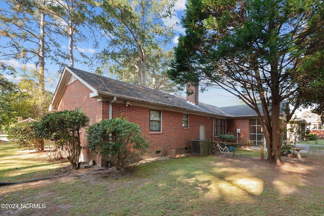 1008 S Howard Cir, Tarboro, NC 27886 - rear view of house with brick siding, cooling unit, a yard, and a chimney