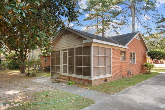 view of property exterior with a sunroom