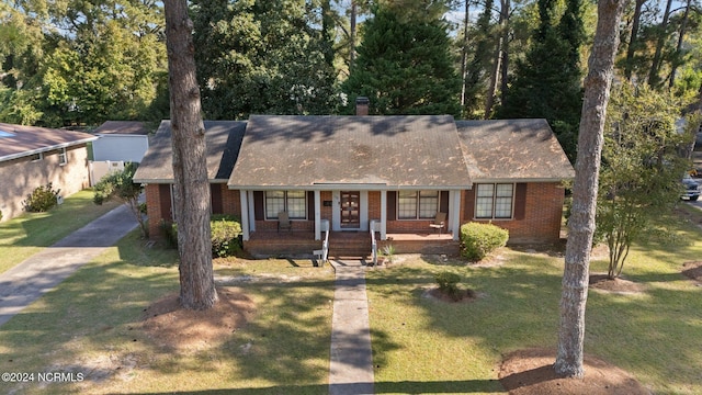1008 S Howard Cir, Tarboro, NC 27886 - view of front of house featuring brick siding, a front yard, a porch, and a shingled roof