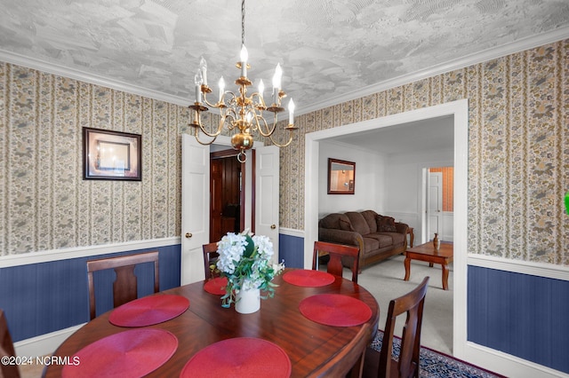 dining room featuring an inviting chandelier, ornamental molding, a textured ceiling, and carpet