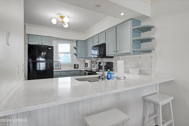 kitchen featuring a breakfast bar, light stone countertops, kitchen peninsula, backsplash, and black appliances