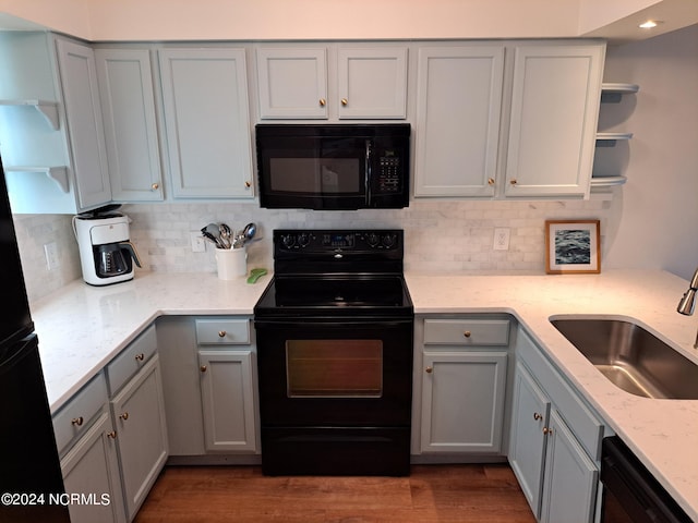 kitchen featuring gray cabinets, sink, light hardwood / wood-style floors, and black appliances