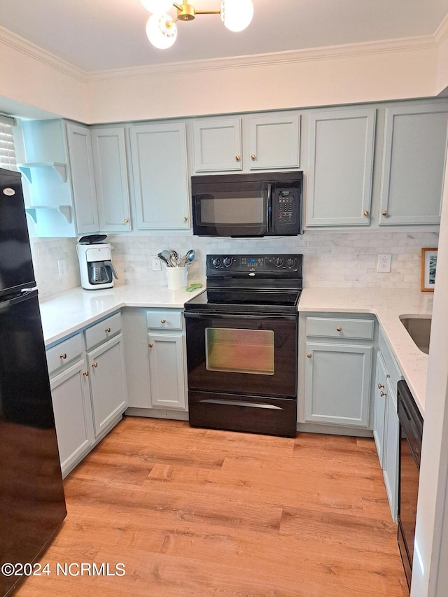 kitchen with ornamental molding, black appliances, backsplash, and light hardwood / wood-style flooring