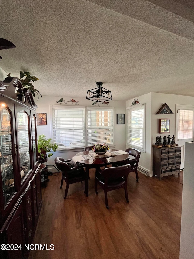 dining room with dark wood-type flooring, a textured ceiling, and ceiling fan