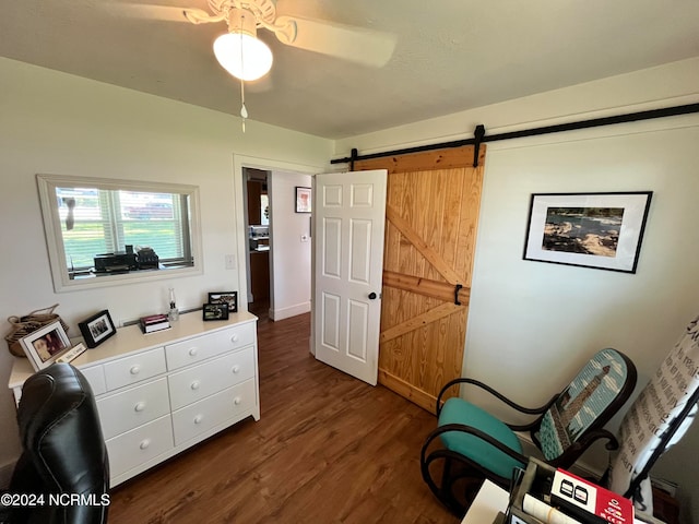 interior space featuring dark wood-type flooring, ceiling fan, and a barn door