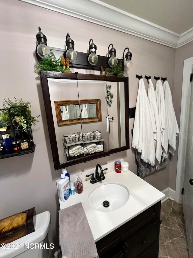 bathroom featuring ornamental molding, vanity, and toilet