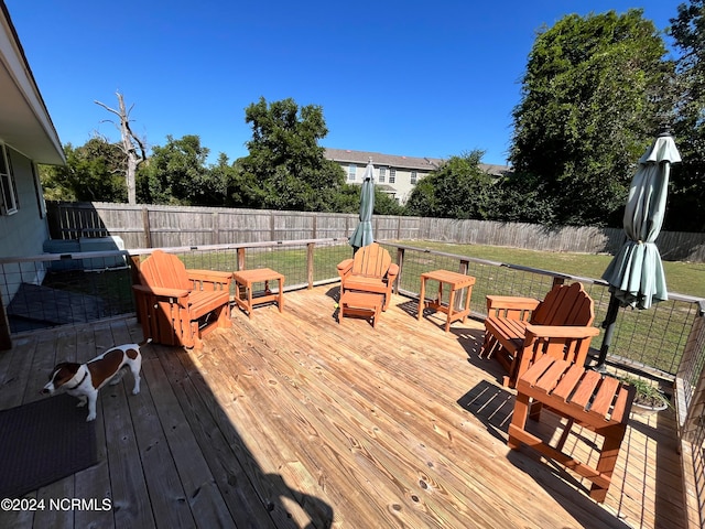 wooden terrace featuring a lawn