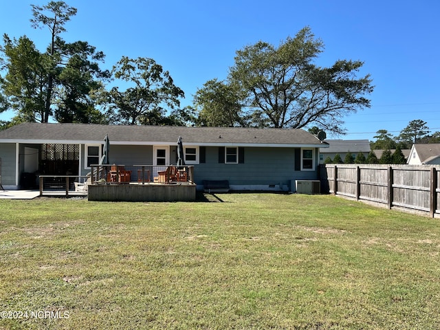 rear view of property featuring cooling unit, a yard, and a wooden deck