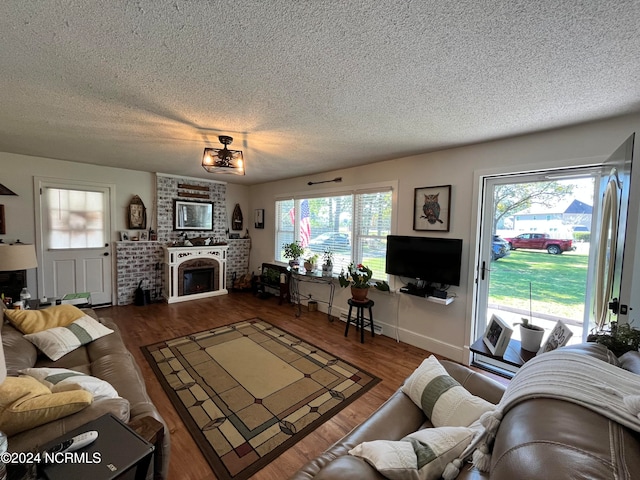 living room with a healthy amount of sunlight, hardwood / wood-style floors, and a textured ceiling