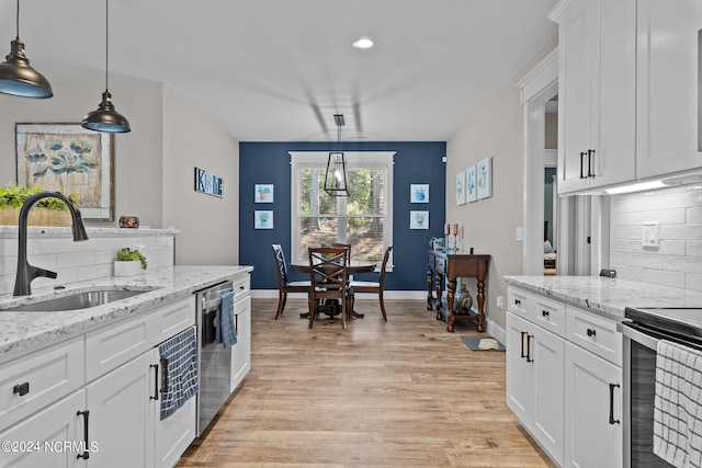 kitchen featuring light hardwood / wood-style flooring, white cabinets, sink, and hanging light fixtures