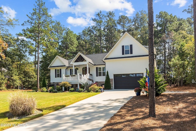 view of front facade featuring a front yard, covered porch, and a garage