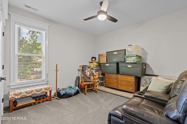 sitting room featuring light carpet, a healthy amount of sunlight, and ceiling fan