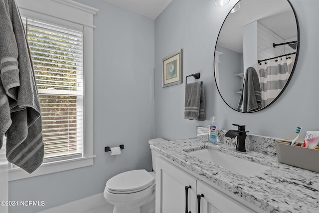 bathroom featuring vanity, toilet, a shower with curtain, and plenty of natural light