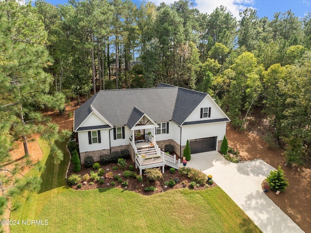 view of front of home with a front lawn, covered porch, and a garage