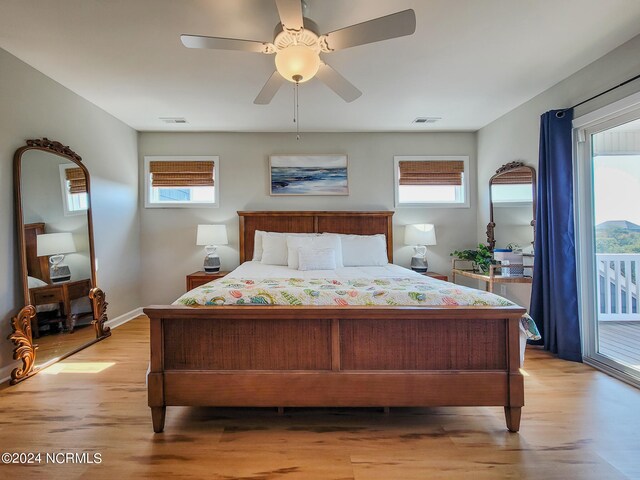 bedroom with access to outside, light hardwood / wood-style flooring, multiple windows, and ceiling fan