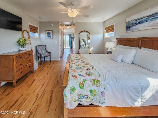 bedroom featuring light hardwood / wood-style floors, multiple windows, and ceiling fan