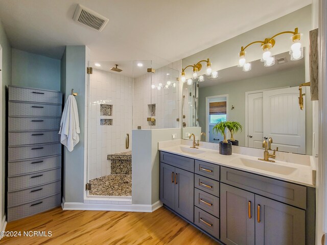 bathroom with a shower with shower door, vanity, and hardwood / wood-style flooring