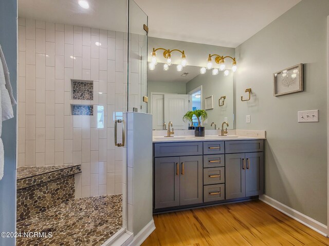 bathroom with wood-type flooring, vanity, and an enclosed shower