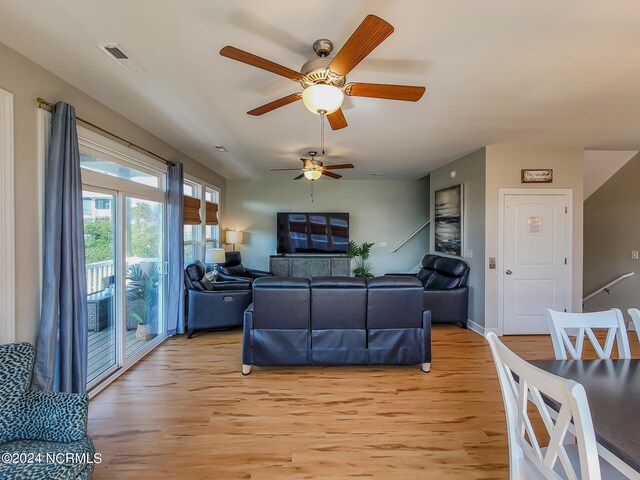 living room with light wood-type flooring and ceiling fan