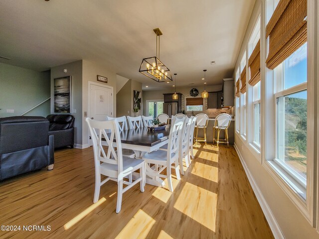 dining space with a notable chandelier and light wood-type flooring