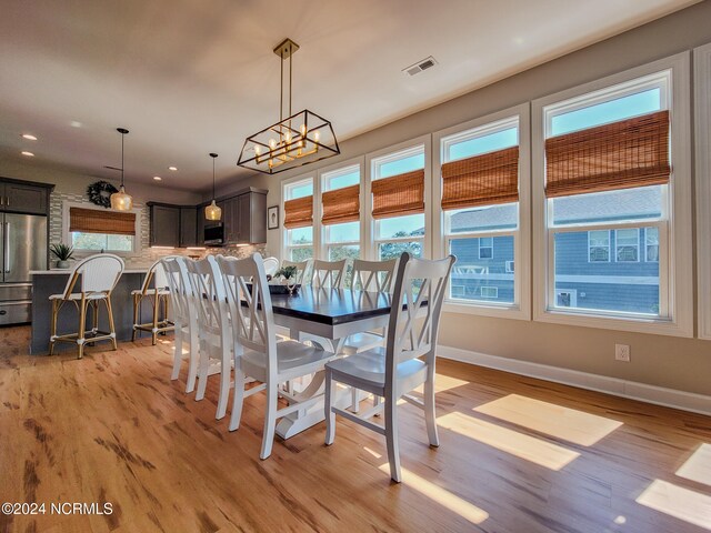 dining area featuring a notable chandelier and light wood-type flooring