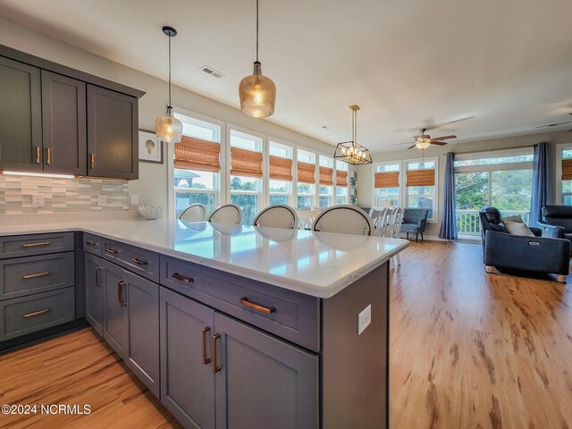 kitchen with backsplash, light hardwood / wood-style floors, and a wealth of natural light